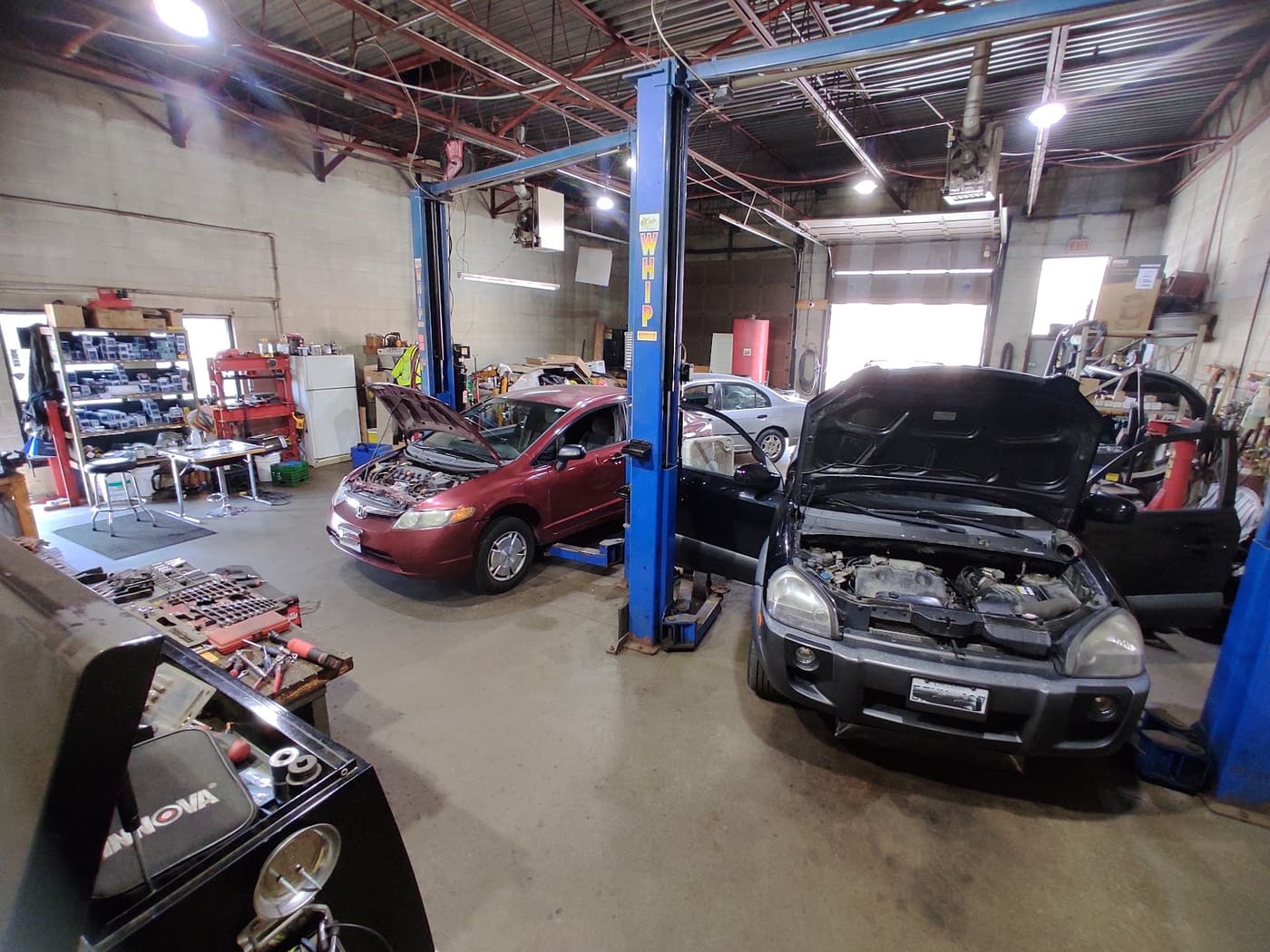 Inside Peel Automotive's shop in Brampton: two hoists, a Civic and a Tucson with their hoods up, tools laid out on the bench.